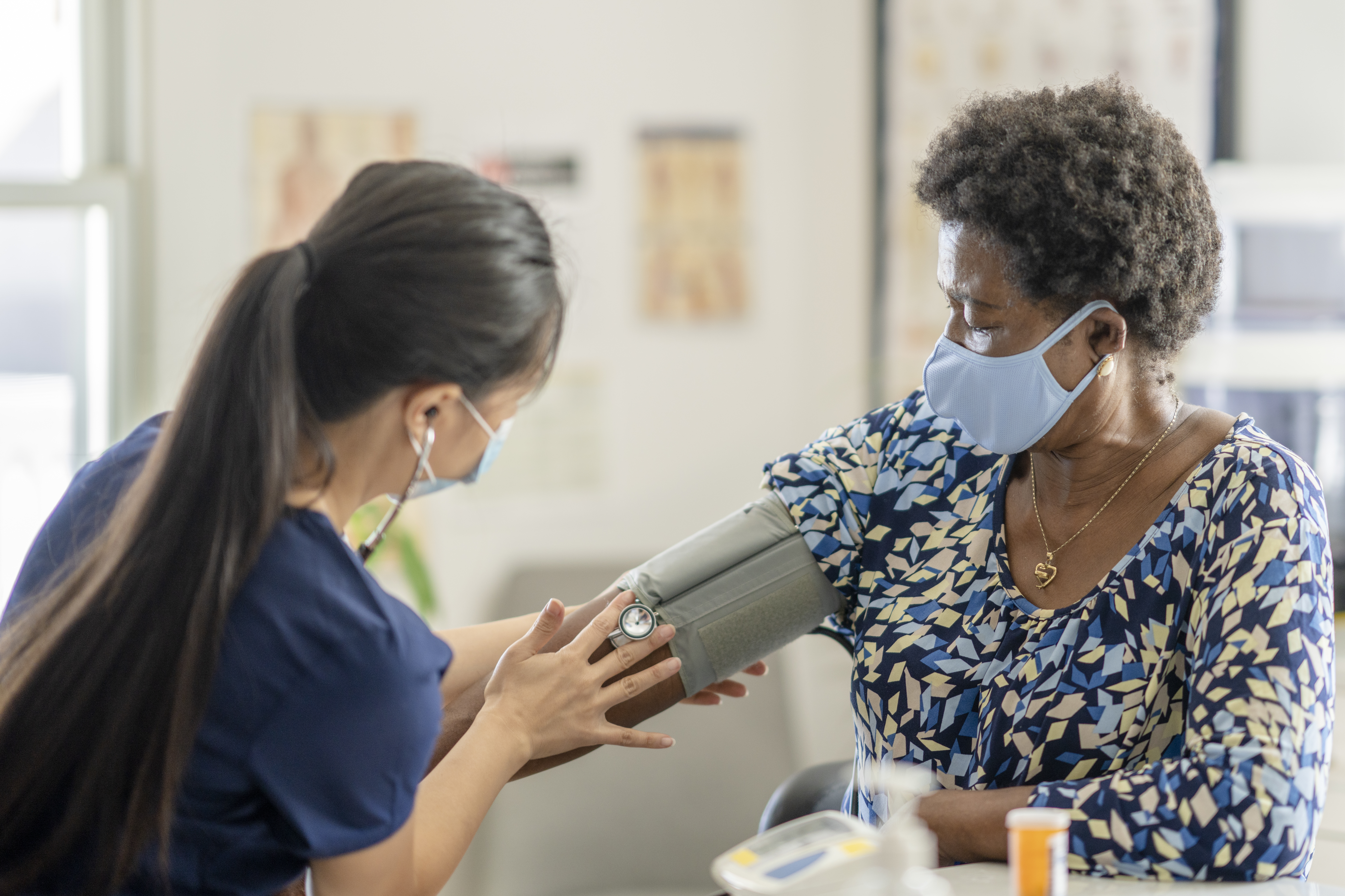 Female Medical Professional Checking Senior Patient’S Blood Pressure