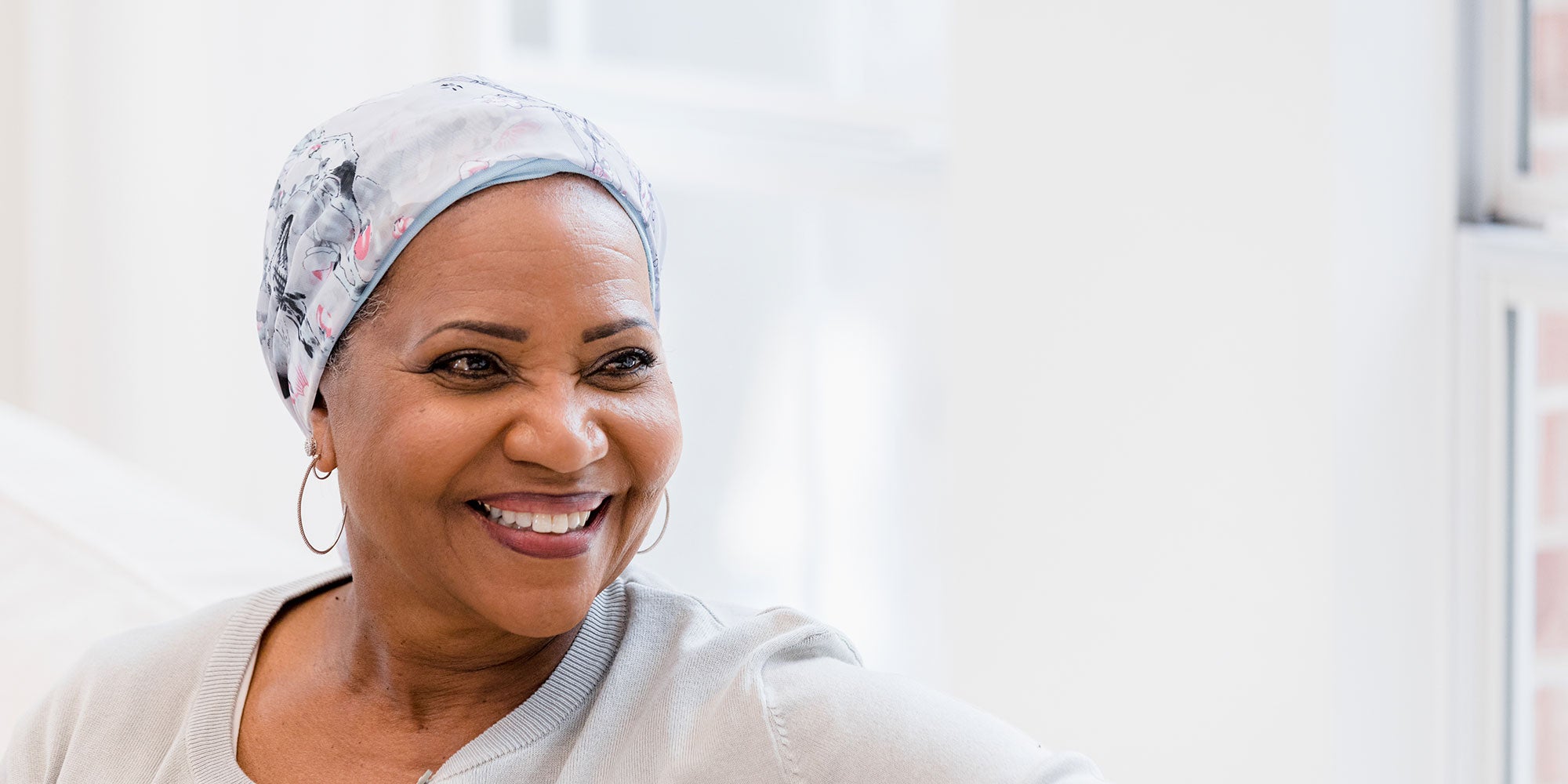 A beautiful woman wears a head wrap and gazes into the distance